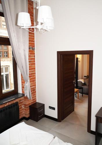 a living room with a door and a window at Aparthotel Łódź 55 Piotrkowska in Łódź