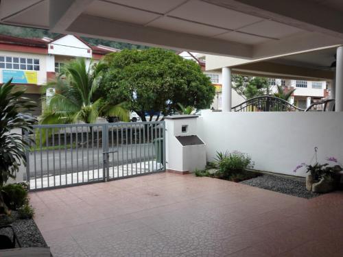 a white fence with a gate in a courtyard at Wong Bentong Makmur Homestay in Bentong