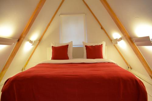 a red bed with two pillows in a room at Rembrandtplein Bed & Breakfast in Amsterdam