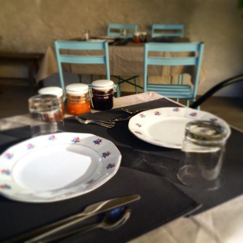 een tafel met twee witte borden met bloemen erop bij Les Toiles du 15 in Montaren-et-Saint-Médiers