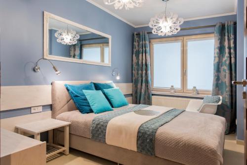 a bedroom with a large bed with blue pillows at Apartament Charisma in Zakopane