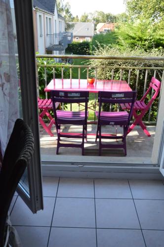 a table and chairs on a porch with a table and chairs at Le Faidherbe in Albert