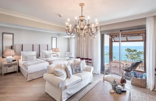 een woonkamer met een kroonluchter en een witte bank bij Allium Bodrum Resort & Spa in Yalıkavak