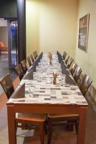 a large long table with chairs in a room at Kukubara Bowling Center in Myszków