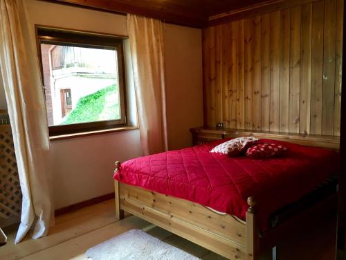 サン・ヴィジリオ・ディ・マレッベにあるAppartamento Ciornaduのベッドルーム1室(赤いベッド1台、窓付)