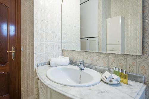 y baño con lavabo y espejo. en Apartamento Imperial, en Torremolinos