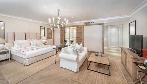 a living room with two white couches and a television at Allium Bodrum Resort & Spa in Yalıkavak