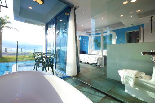 a bathroom with a tub and a bedroom with a view at Hualien S.E.A. B&B in Hualien City