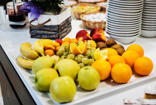 a tray of fruit on a table with plates at Hotel Bisesti ***S in Garda