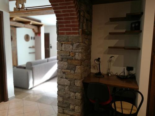 uma sala de estar com um sofá e uma parede de tijolos em Appartamento Rosa em Aosta