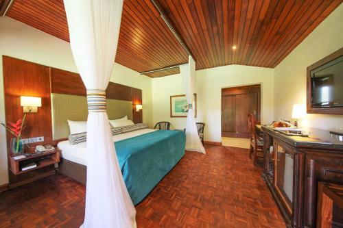 a hotel room with a bed with a canopy at Muthu Lake Naivasha Country Club, Naivasha in Naivasha
