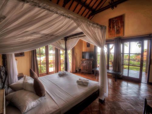 Un pat sau paturi într-o cameră la Puri Mangga Sea View Resort and Spa