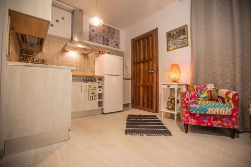 eine Küche mit einem roten Stuhl und einem Kühlschrank in der Unterkunft Buddhalounge Apartments in Ronda
