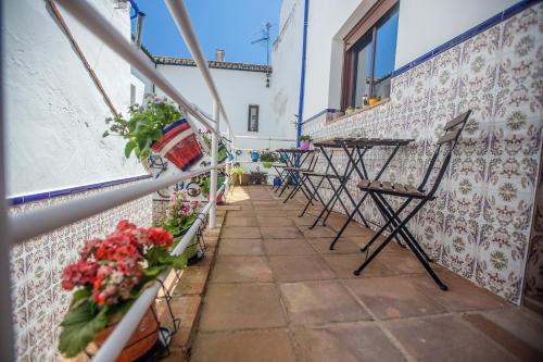 une rangée de tables et de chaises sur un balcon fleuri dans l'établissement Buddhalounge Apartments, à Ronda