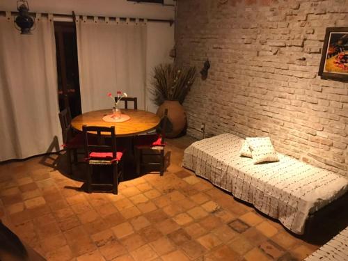 a bedroom with a table and a bed and a brick wall at Bajo el Faro in Colonia del Sacramento