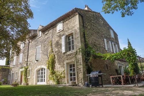 un viejo edificio de ladrillo con un cubo de basura delante de él en Le Moulin de Montségur, en Montségur-sur-Lauzon