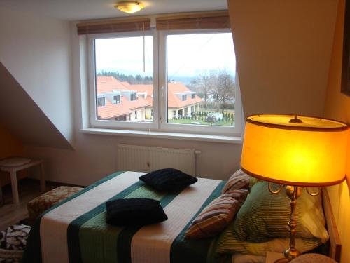 a bedroom with a bed with a lamp and a window at Apartamenty Słoneczna Polanka in Polanica-Zdrój