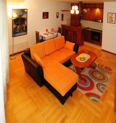 sala de estar con sofá naranja y mesa en Apartman Lili, en Vrnjačka Banja
