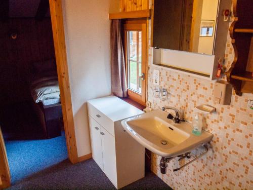 a small bathroom with a sink and a mirror at Chalet Panorama in Rosswald