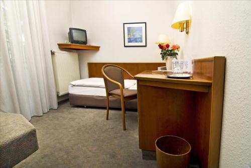 a hotel room with a desk and a bed at Hotel Stiftswingert in Mainz