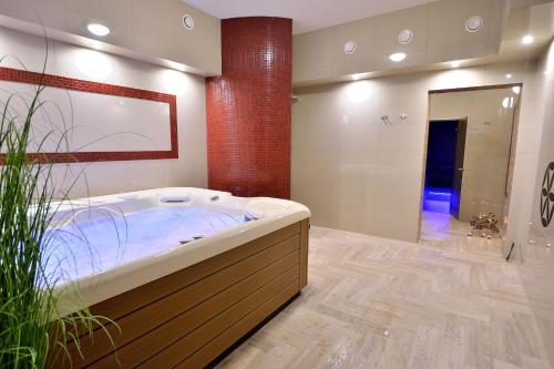 ein großes Bad mit einer Badewanne und einer Dusche in der Unterkunft Grand Podhale Resort&Spa- Jacuzzi - Sauna fińska i Łaźnia parowa - Widok na Tatry in Zakopane