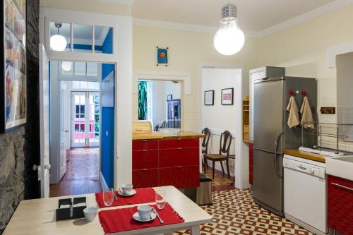 a kitchen with a refrigerator and a table in a room at Casa dos Francelhos in Funchal