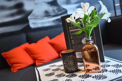 a table with a vase of flowers and a box at ibis Charleroi Airport Brussels South in Charleroi