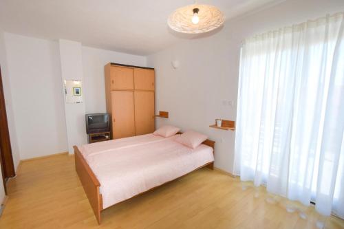 a bedroom with a bed and a large window at Apartments Vera in Malinska