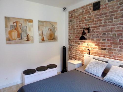 a bedroom with a bed and a brick wall at Spichlerz II Old Town Apartment in Warsaw