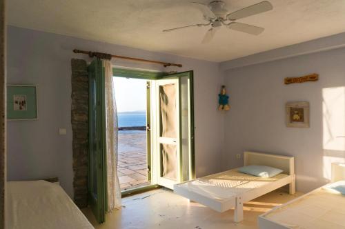 a bedroom with a door open to a view of the ocean at Villa Juno in Kea in Koundouros