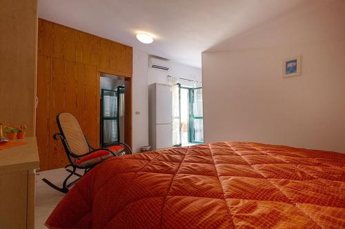 een slaapkamer met een bed en een stoel erin bij bb Al Centro Di Vietri in Vietri