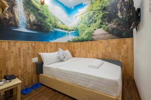 a bed in a room with a painting on the wall at Beauty House in Ho Chi Minh City