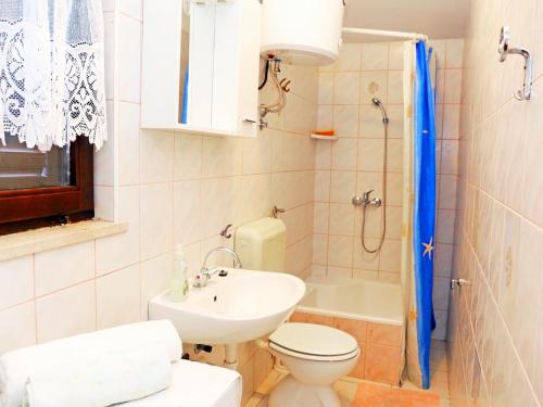a bathroom with a sink and a toilet and a shower at Apartments Slavko in Trogir