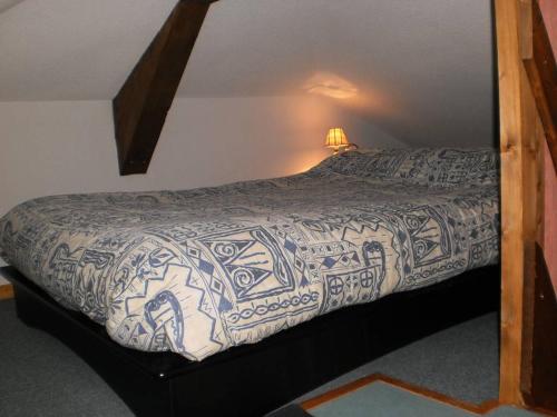 a bedroom with a bed with a blue and white bedspread at Location Montagne in Les Contamines-Montjoie