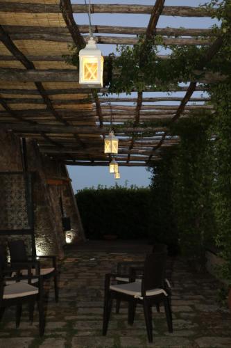a patio with tables and chairs under a wooden pergola at Agriturismo Materno in Radicondoli