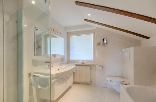 a white bathroom with a sink and a toilet at Appartment Maria in Schenna