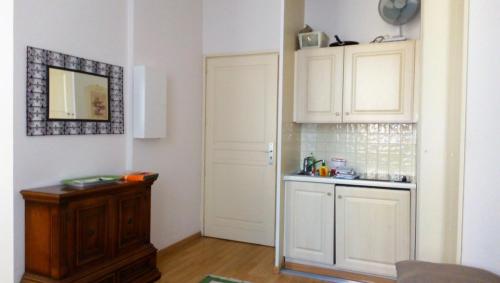 - une cuisine avec des placards blancs, un évier et une porte dans l'établissement Appartement La Cerisaie - Rue Massena, à Nice