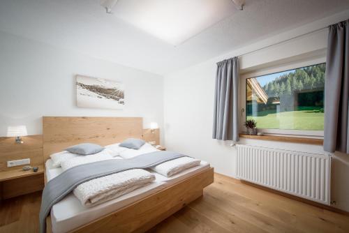 Schlafzimmer mit einem Bett und einem Fenster in der Unterkunft Gästehaus Hain in Hochfilzen