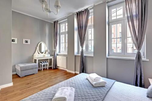 a bedroom with two beds and a mirror and windows at Platinium Ogarna Old Town in Gdańsk