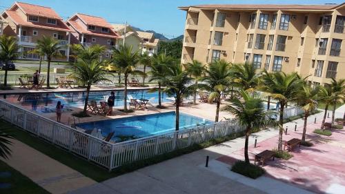 an overhead view of a resort swimming pool with palm trees at Condado Aldeia dos Reis in Mangaratiba