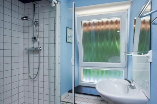 baño con lavabo y ventana en Les 3 Canards en Stoumont