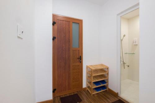 a bathroom with a wooden door and a walk in shower at Beauty House in Ho Chi Minh City
