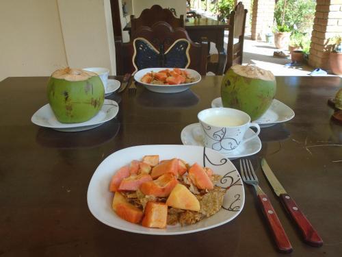a table with plates of food and cups of coffee at Ecolodge Blue Morpho in Cárdenas