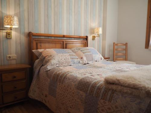 a bed in a bedroom with two lamps and a dresser at Reconquista in Benasque