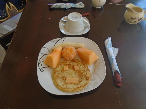 a plate of food with pancakes and fruit on a table at Ecolodge Blue Morpho in Cárdenas