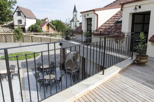 a fence with chairs and tables on a deck at PROSECCO RESIDENCE MARKO in Valtice