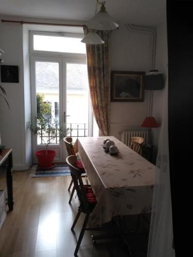 a dining room with a table and a window at Maison Lapeyriere in Le Dorat