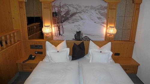 a bedroom with two white pillows on a bed at Hotel Almhof in Hochfugen