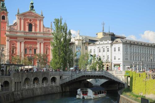 a bridge over a river in a city with buildings at Emona Guesthouse Ljubljana in Ljubljana