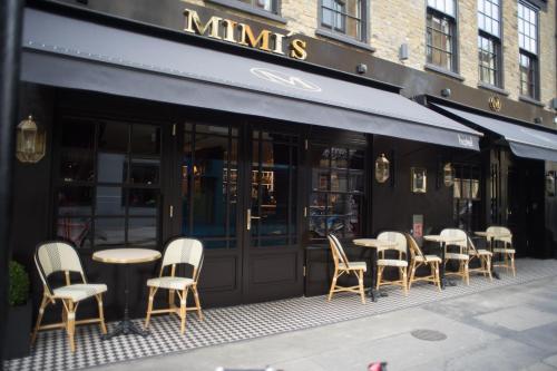 a group of tables and chairs outside of a restaurant at Mimi's Hotel Soho in London